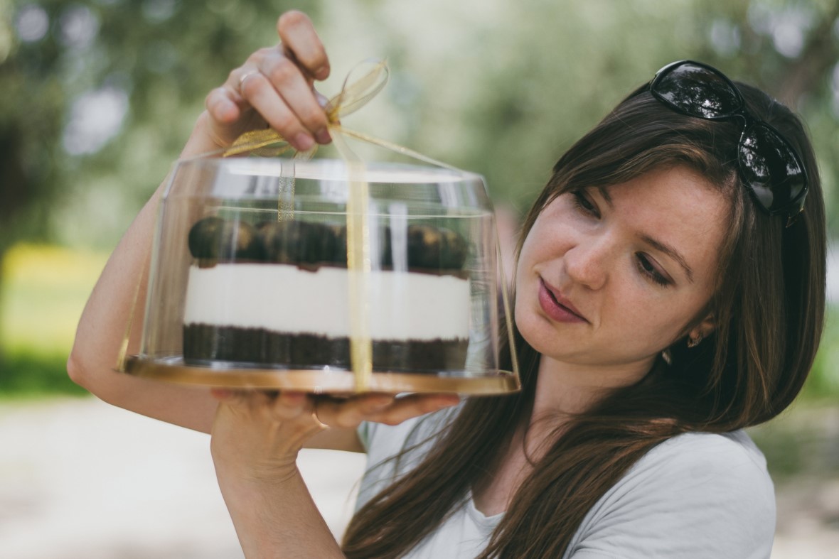 Woman storing a cake in plastic box but a cardboard box is better